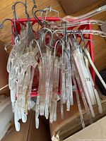 Crate of clear plastic shirt hangers with metal hooks