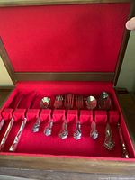 Open chest showing dinner knives, spoons and forks in red felt slots