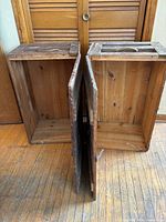 Two wooden crates standing open showing interiors