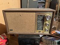 Front view showing wood cabinet, fabric grille, tuning dial, knobs and Realistic branding