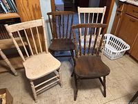 three spindle-back chairs showing mixed finishes and wear