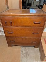 Front view of vintage 3-drawer dresser showing finish, handles, and wear