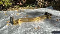 Full view of brass fireplace fender on tarp outdoors