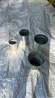 All four galvanized pots displayed on tarp