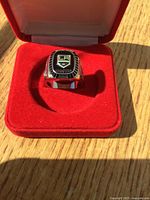 Front view of ring in open red box showing LA logo and Champions text