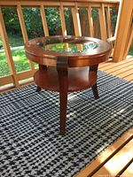 Side view of round wood table on balcony rug