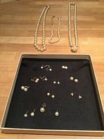 Overview of all three necklaces and earrings laid in tray