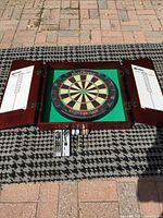 Cabinet open flat showing dartboard and doors with scoreboards