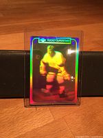 Front view of holographic sticker card inside top loader