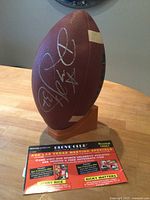 Football on stand showing Rickey Watters signature and flyer