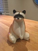 Front view of glazed ceramic raccoon figurine