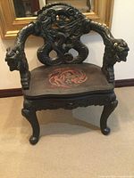 Front view showing carved dragons on backrest and arms, painted red dragon on seat
