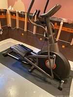 Side view of AFG elliptical showing frame, handlebars, flywheel cover