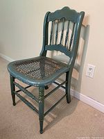 Front view of antique green painted side chair showing caned seat and turned legs