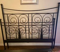 Full view of wrought iron headboard and footboard showing scroll design
