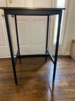 Full front and side view of bar-height table showing frame and crossbar