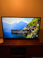 TV powered on displaying “No Signal” screen on stand