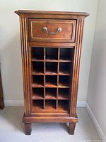 Front view showing drawer, 12-bottle rack, fluted sides, squared legs