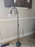 Full view of floor lamp showing base, pole, scroll arm, and shade