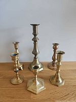 All six brass candle holders grouped on surface