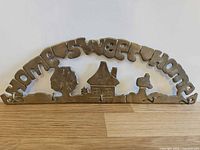 Front view showing arched brass key rack with "HOME SWEET HOME" text, house scene and five hooks
