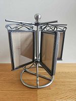 Full view of metal carousel showing five frames and round base