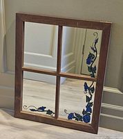 Full view of window-pane mirror showing frame, mirrored glass, and painted floral vines