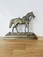 Full view of brass horse doorstop on base