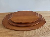 Three nested wooden trays showing size gradation