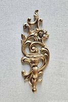 Front view showing complete gold Rococo wall sconce with floral motif and candle cup