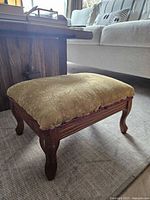 Footstool angled view showing wood frame and upholstery