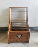 Front view of wooden magazine rack showing heart cutout and dowel bars