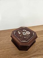 Angled view of closed octagonal wooden jewelry box on tabletop