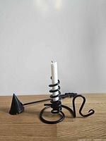 Side view of spiral candle holder with snuffer and demonstration candle