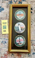 Full view of framed piece with three round lighthouse ornaments