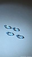 Four marquise-cut blue topaz gemstones under light