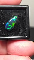 Pear cabochon in display box showing multicolored play-of-color