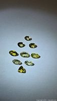 Group of nine faceted yellow-green tanzanites on white background