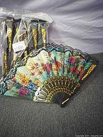 Packaged set of folding fans with one opened to show design