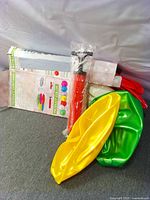 Boxed kit with pump and deflated colored inflatables visible