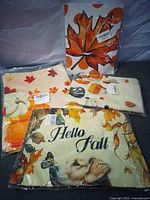 Four packaged fall-themed items: pillow cover, table runner, additional textile, maple leaf decal