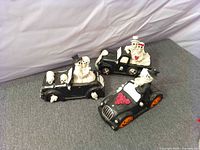 Three Halloween skeleton couple car figurines on grey surface