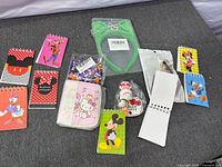 All items laid out showing notepad covers, Hello Kitty pouch, packaged keychains, headband and confetti