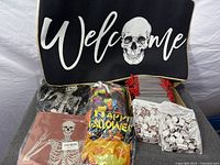 overview of all Halloween items including welcome mat, skeleton, napkins, banner, treat bags and favor boxes