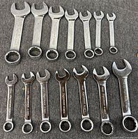 Both rows of short open-end and combination wrenches displayed on grey background