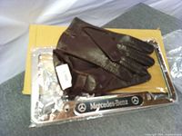 Brown leather gloves placed on boxed chrome Mercedes-Benz license plate frame