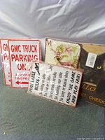 Group of five sealed novelty tin signs standing upright