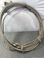 Coiled steel wire rope with hook showing overall condition and fittings
