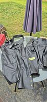 Chaps and jacket laid flat on table showing overall condition