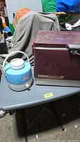 Cooler and jug side by side on table